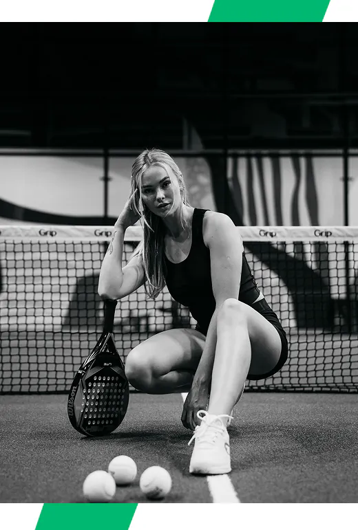 Padelimängija naisterahvas toetub padeli reketile